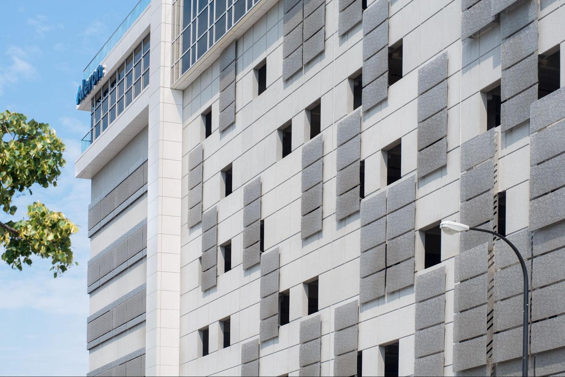 grey and white precast panels on the side of a parking garage