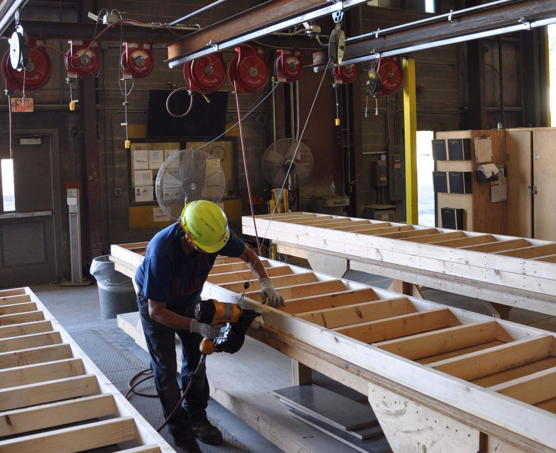 a precaster working on the wooden framing of a precast concrete panel.